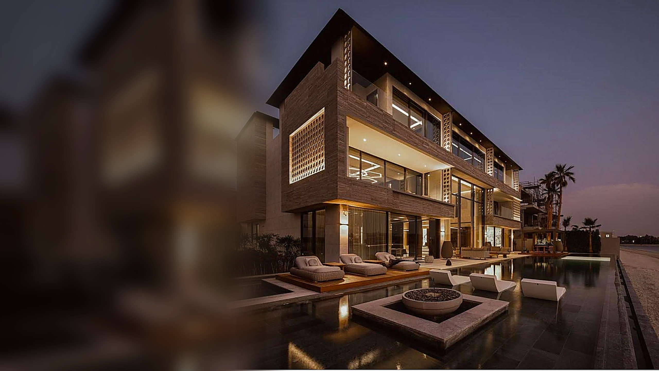 Illuminated luxury residence with natural stone architecture and pool